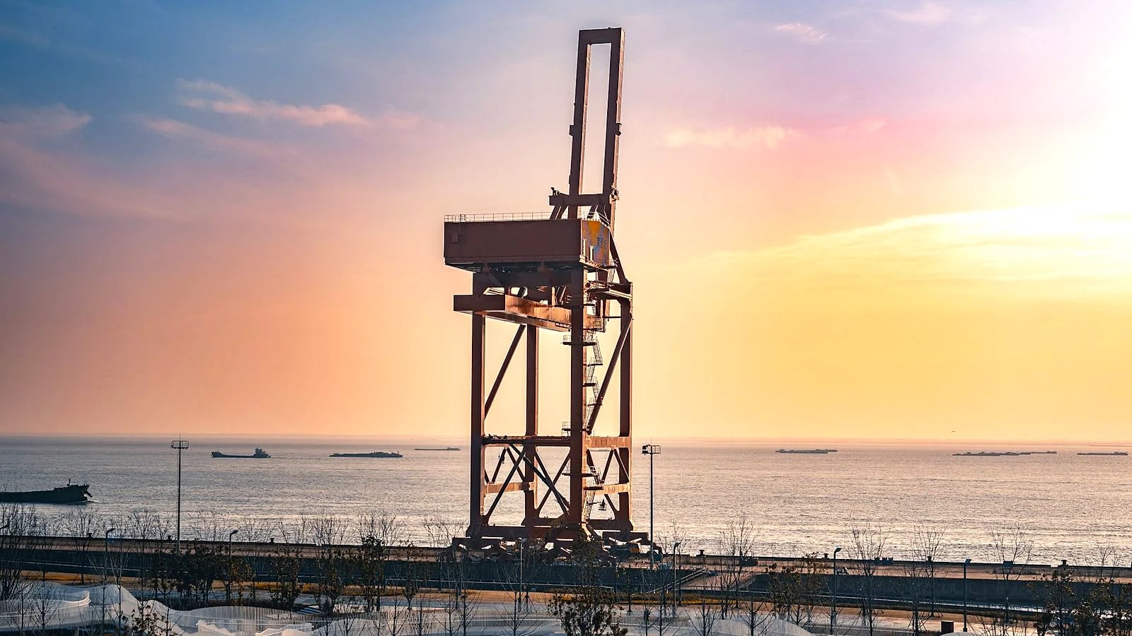 An offshore oil and gas platform silhouetted against a sunset sky