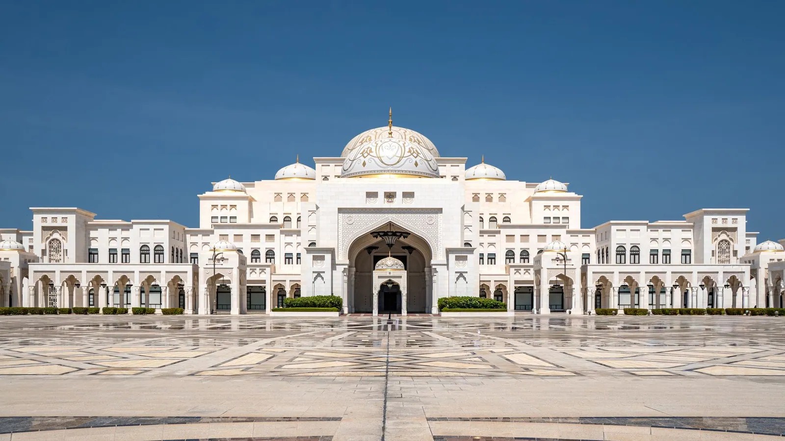 Qasr Al Watan presidential palace in Abu Dhabi, its white domes gleaming under a clear blue sky